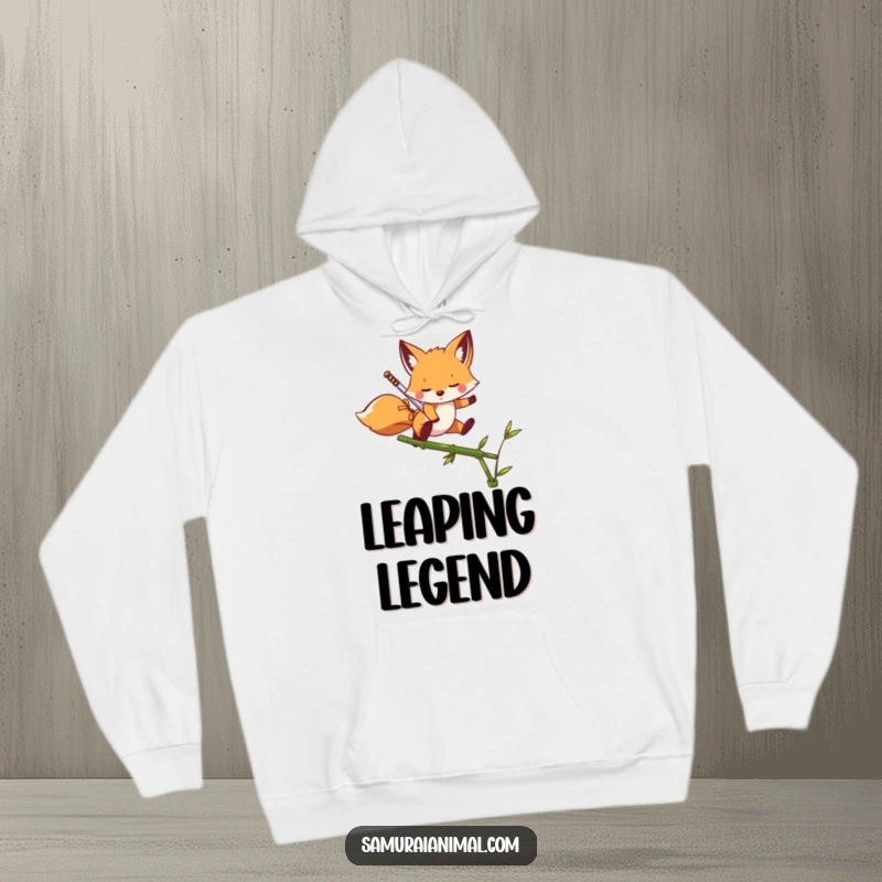 Funny Hoodie with a playful fox holding a miniature sword, dynamically leaping over a bamboo shoot.