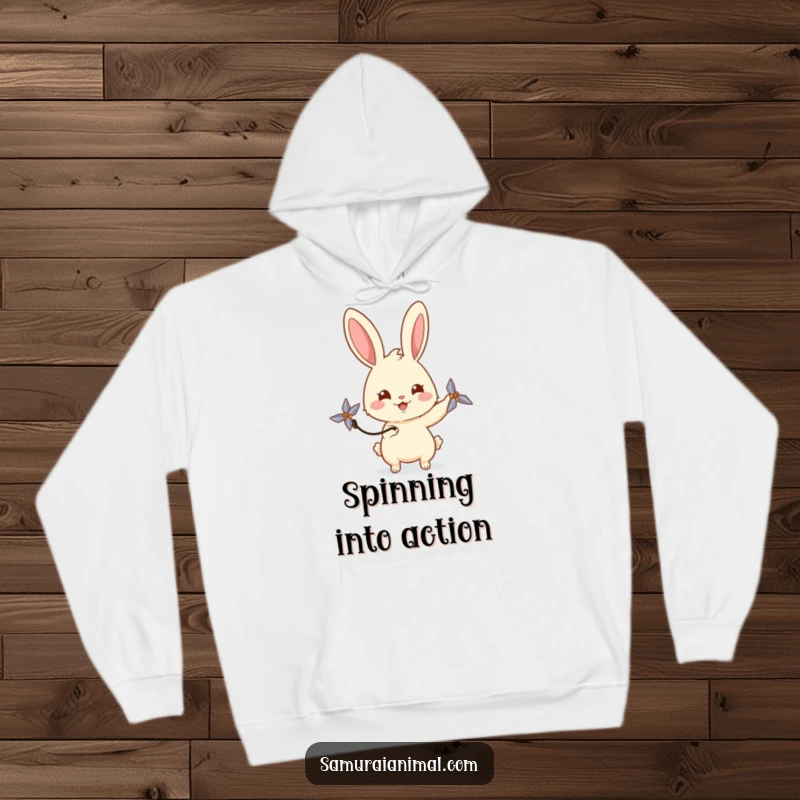 Funny rabbit hoodie showing a happy bunny playfully spinning a miniature shuriken with a curious gaze, offering cozy warmth.